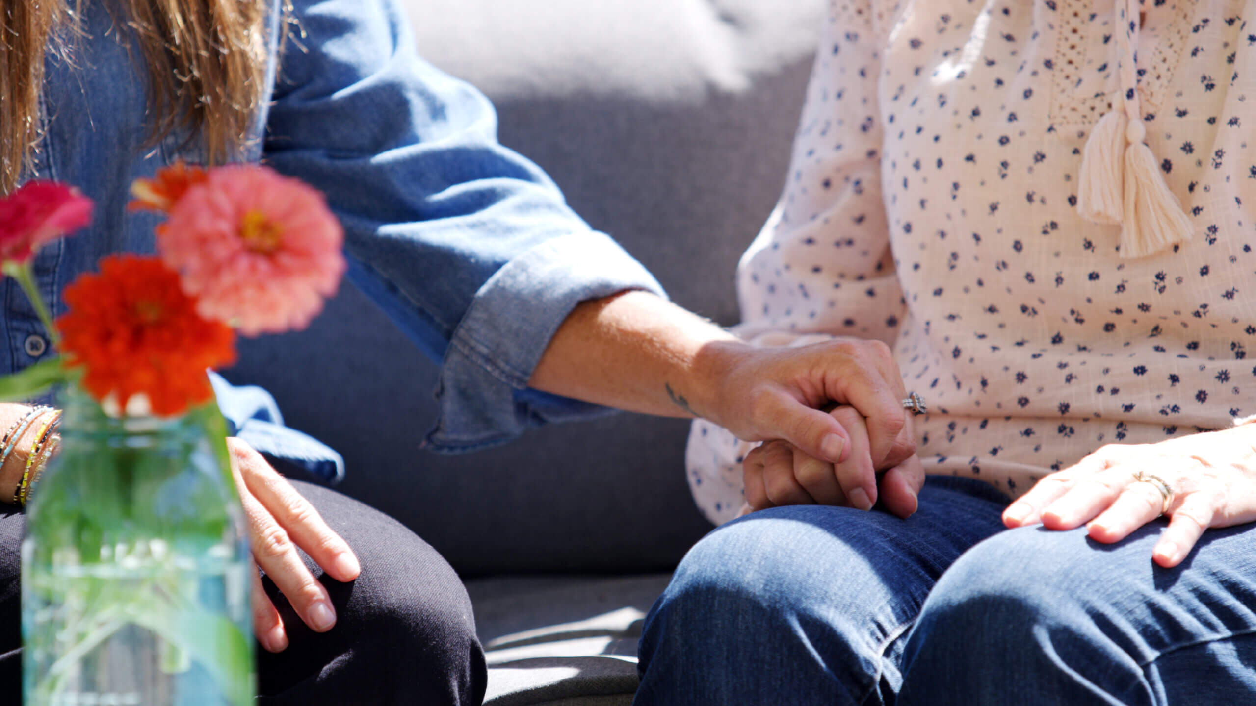 Caregiver holds the hand of a patient with Alzheimer's Disease.